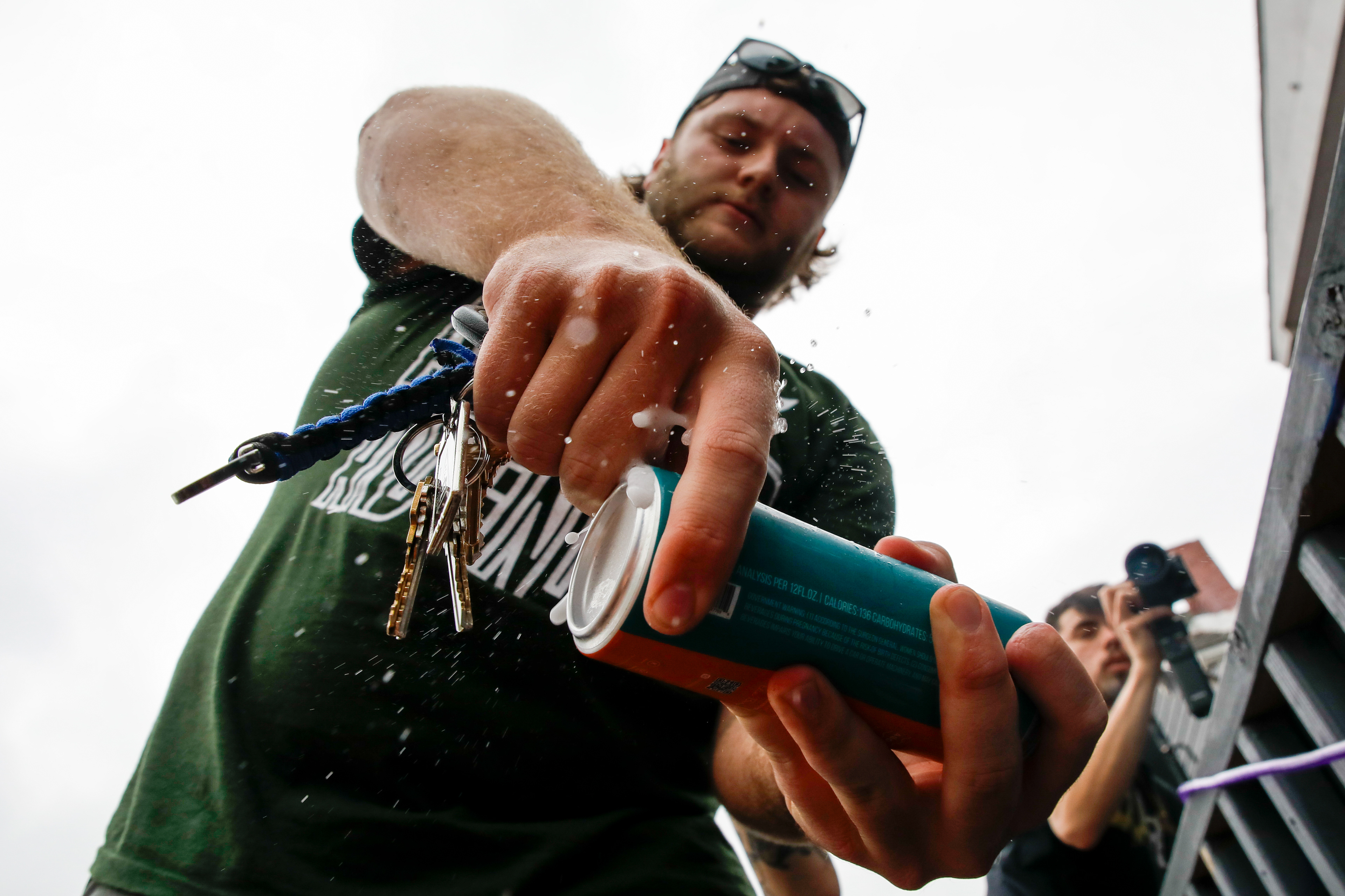 Ohio University students shotgun a BORG vodka water during Athens Fest on Hocking Street, Athens, Ohio, April 19, 2024