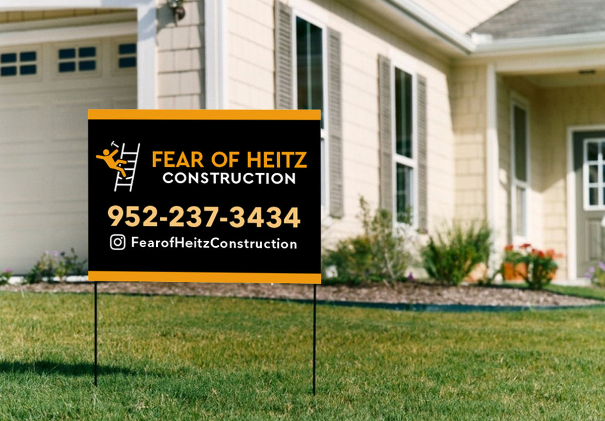 Lawn sign in front of a house with contact information for Fear of Heitz Construction