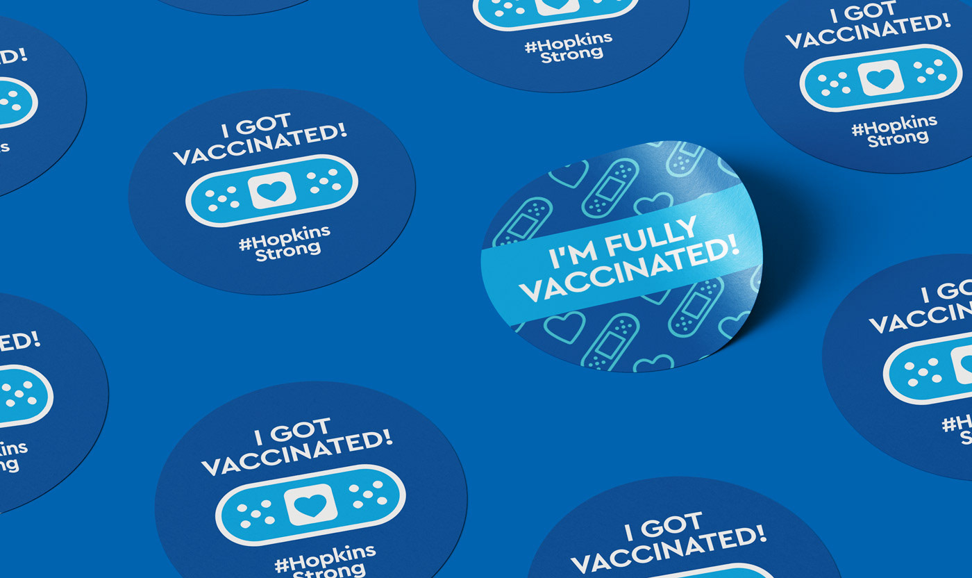 Stickers that read "I got vaccinated" and "I'm fully vaccinated" with bandaid iconography on a blue background.