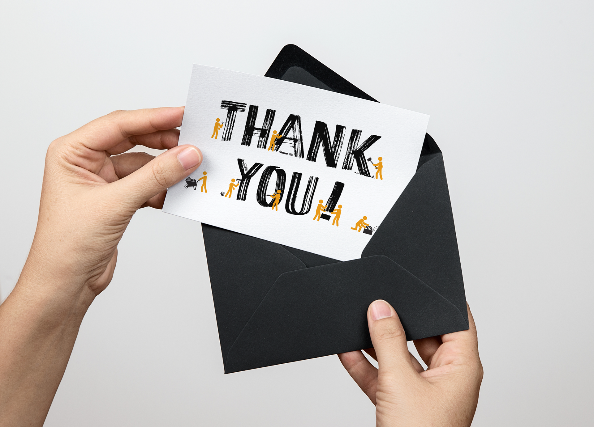 Hands holding a black envelope and a white thank you card.