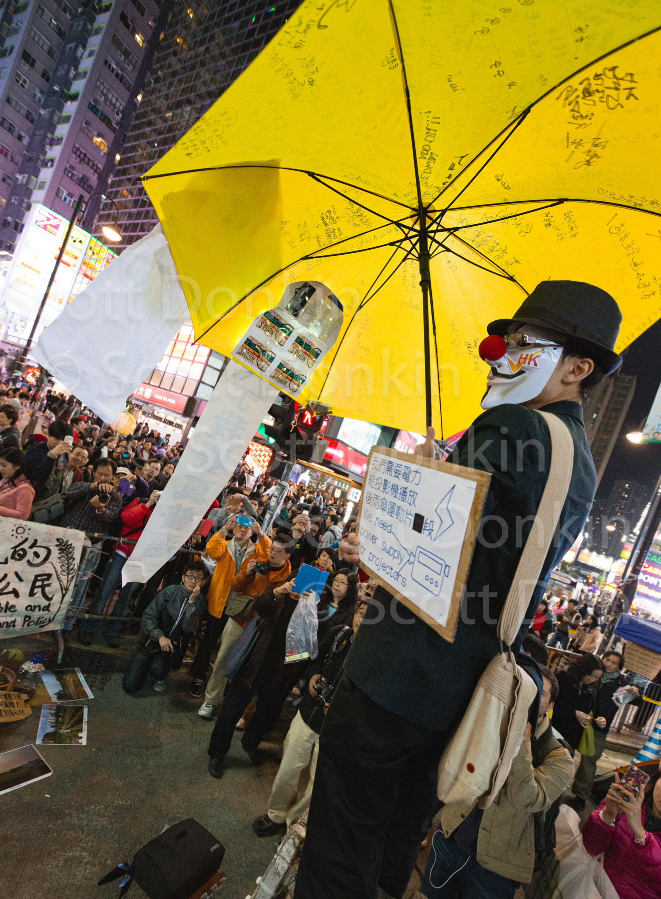 HONG KONG, CHINA - 14 December 2014: A man in a mask disguise stands on a soap box before crowds holding a symbolic umbrella during the Umbrella Protest, so named for the the use of umbrellas to resist Police use of pepper spray to disperse the crowd during a 79-day occupation of the city demanding more transparent elections.