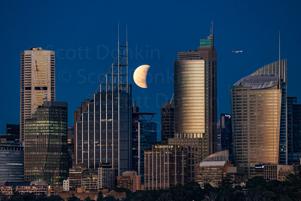 SYDNEY, NSW, AUSTRALIA - 17 July 2019: Single exposure of a partial Lunar Eclipse over the Sydney Skyline at dawn.
