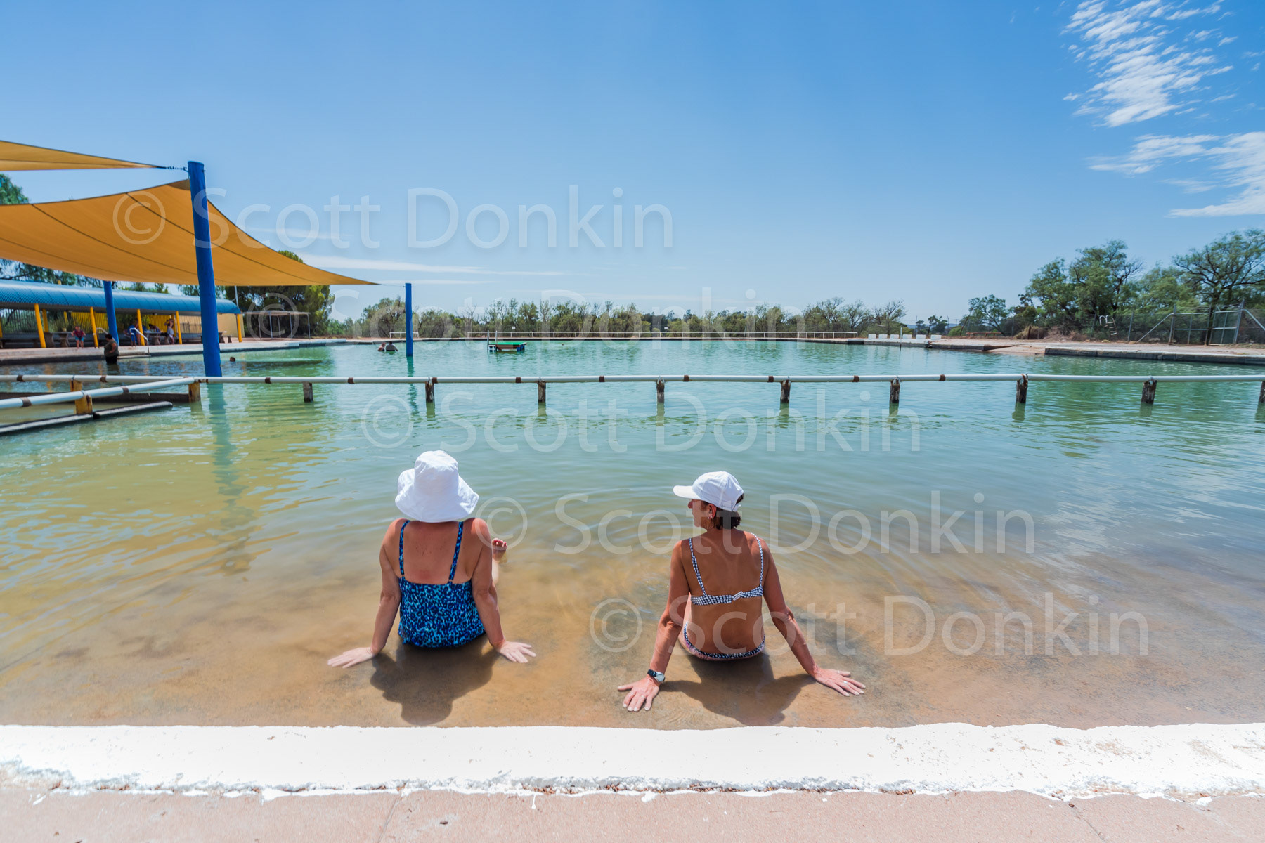 BARMEDMAN, NSW, AUSTRALIA - 3 February 2019: Two bathers enjoy the sunshine in the community therapeutic Mineral Salt Pool.