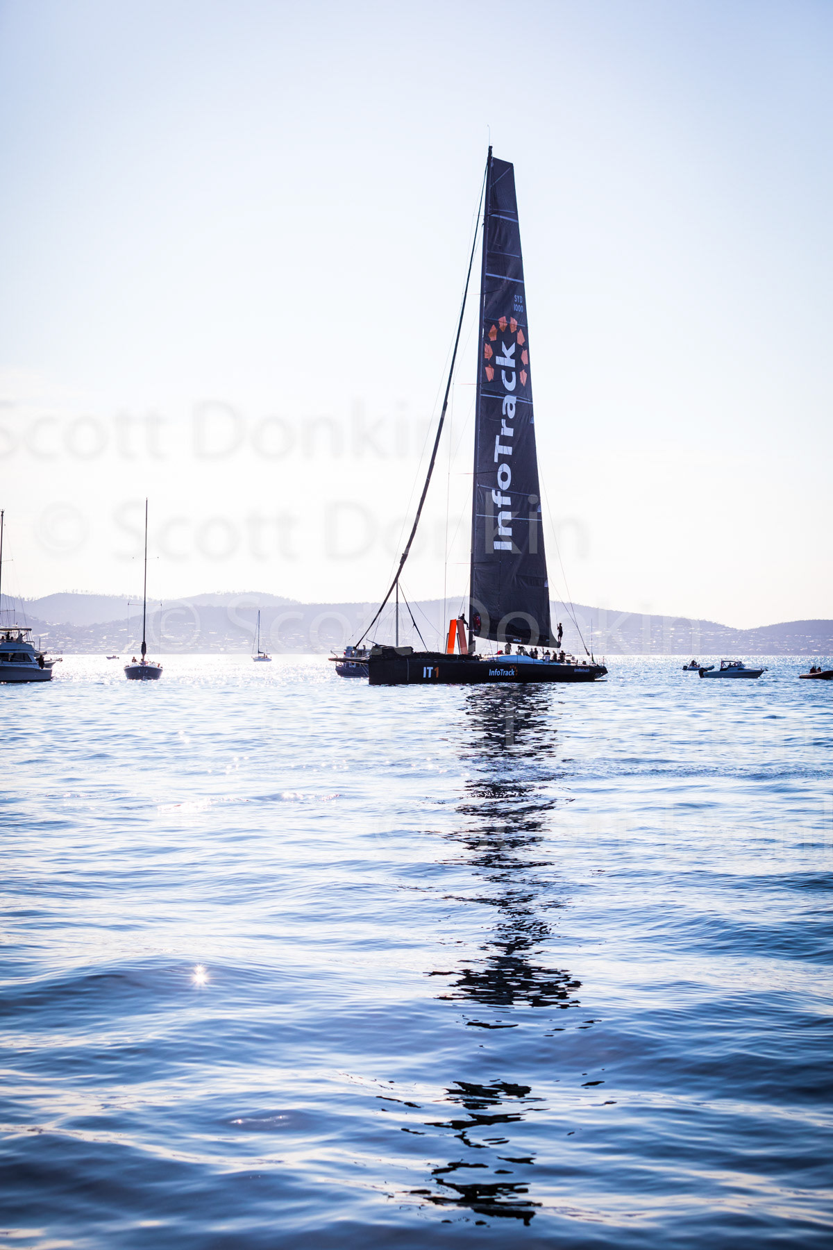 HOBART, TAS, AUSTRALIA - 28 December 2019: 100ft Super Maxi InfoTack, placing second for Line Honours in the 2019 Rolex Sydney Hobart Yacht Race, sits in the comparatively calm waters of the Derwent River shortly after crossing the finish line..