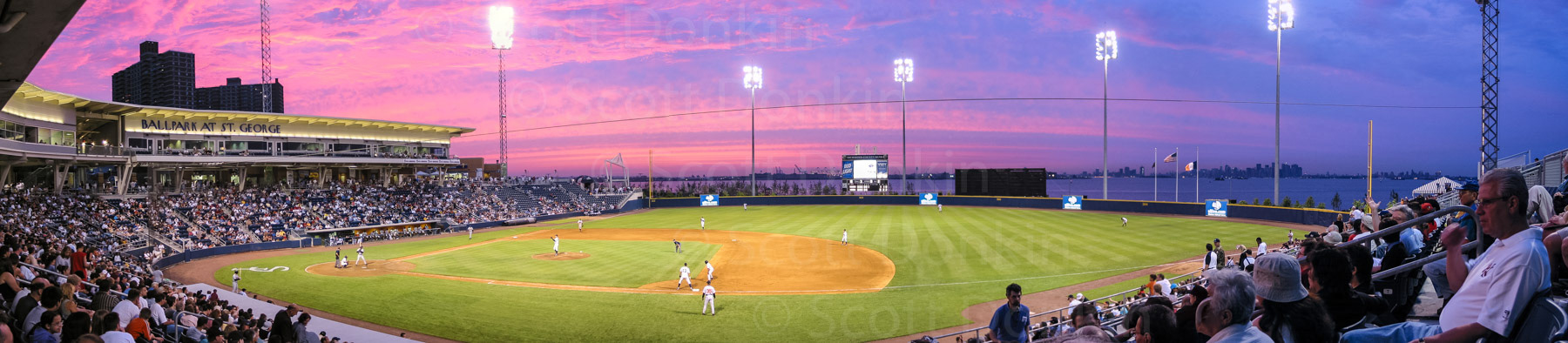STATEN ISLAND, NEW YORK, USA - 13 July 2002: Eight months after the events of 9/11 and in the shadow of the New York city skyline, locals fill the stands at St George Ballpark to watch a Staten Island Yankees baseball game. Stitched panorama.