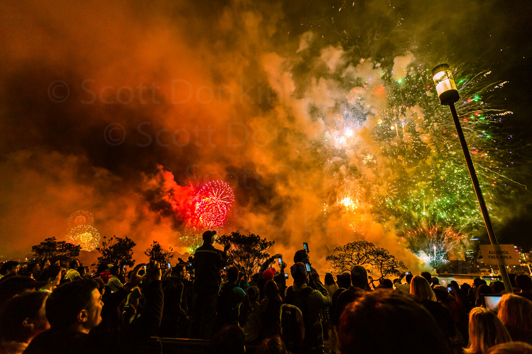 SYDNEY, NSW, AUSTRALIA - 1 January 2016: Revellers welcome in the New Year against a background of the Sydney Harbour New Year Fireworks display.