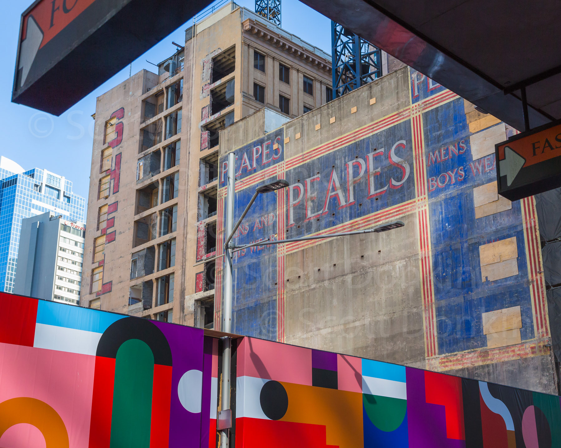 SYDNEY, AUSTRALIA - 15 September 2017: Demolition work on the site of the old Menzies Hotel and Thakral House buildings has revealed a well-preserved colourful advertising sign for the "Peapes Menswear" store adjacent to the Wynyard construction site.  This large painted advertisement, popularly referred to as a 'ghost sign', was revealed on the side of Beneficial House, formerly occupied by Peapes Menswear from 1923 to 1970.  Once construction is completed, the Peapes sign will again be covered and expected not to see daylight again for at least another fifty years.