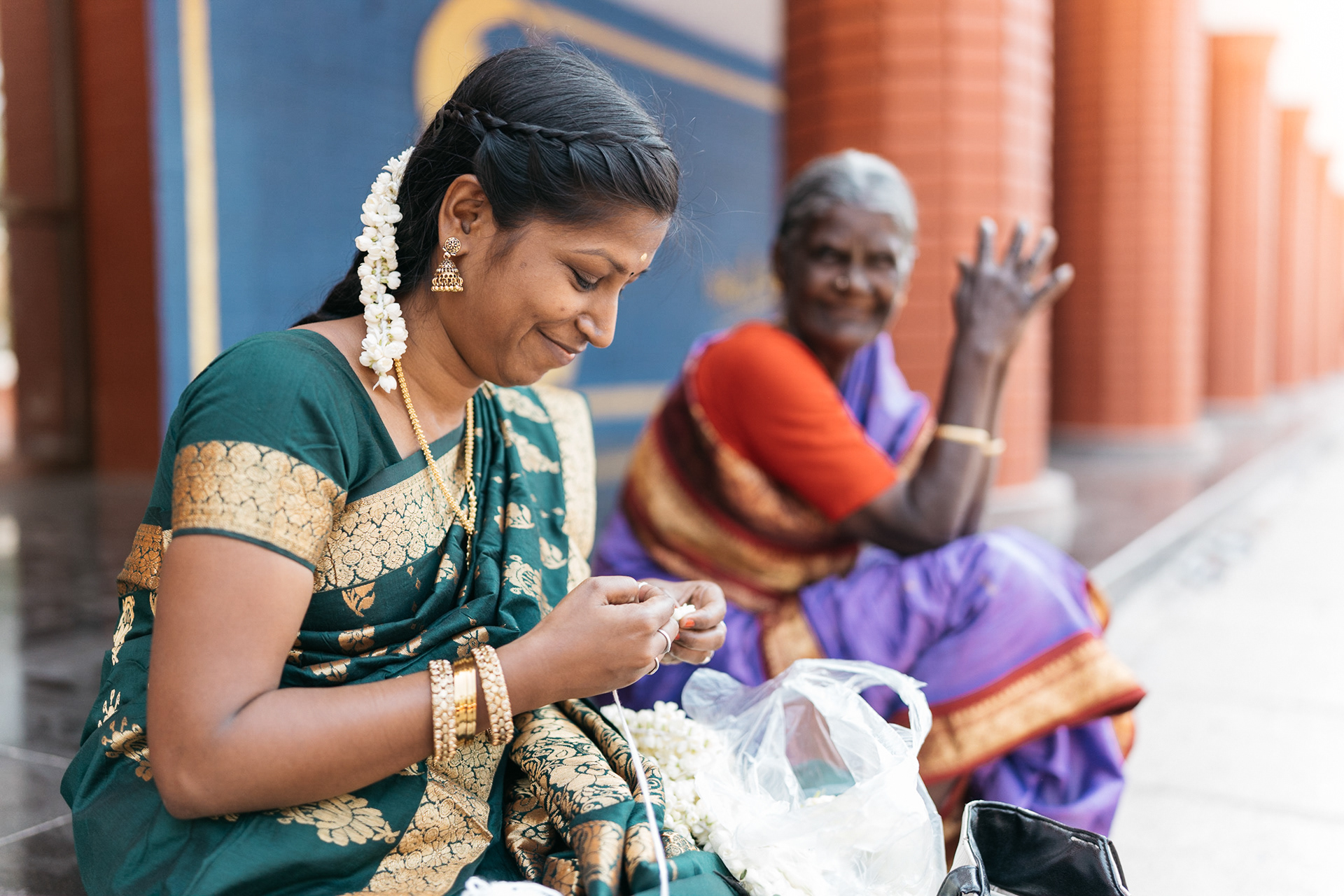 Women enjoy making garland