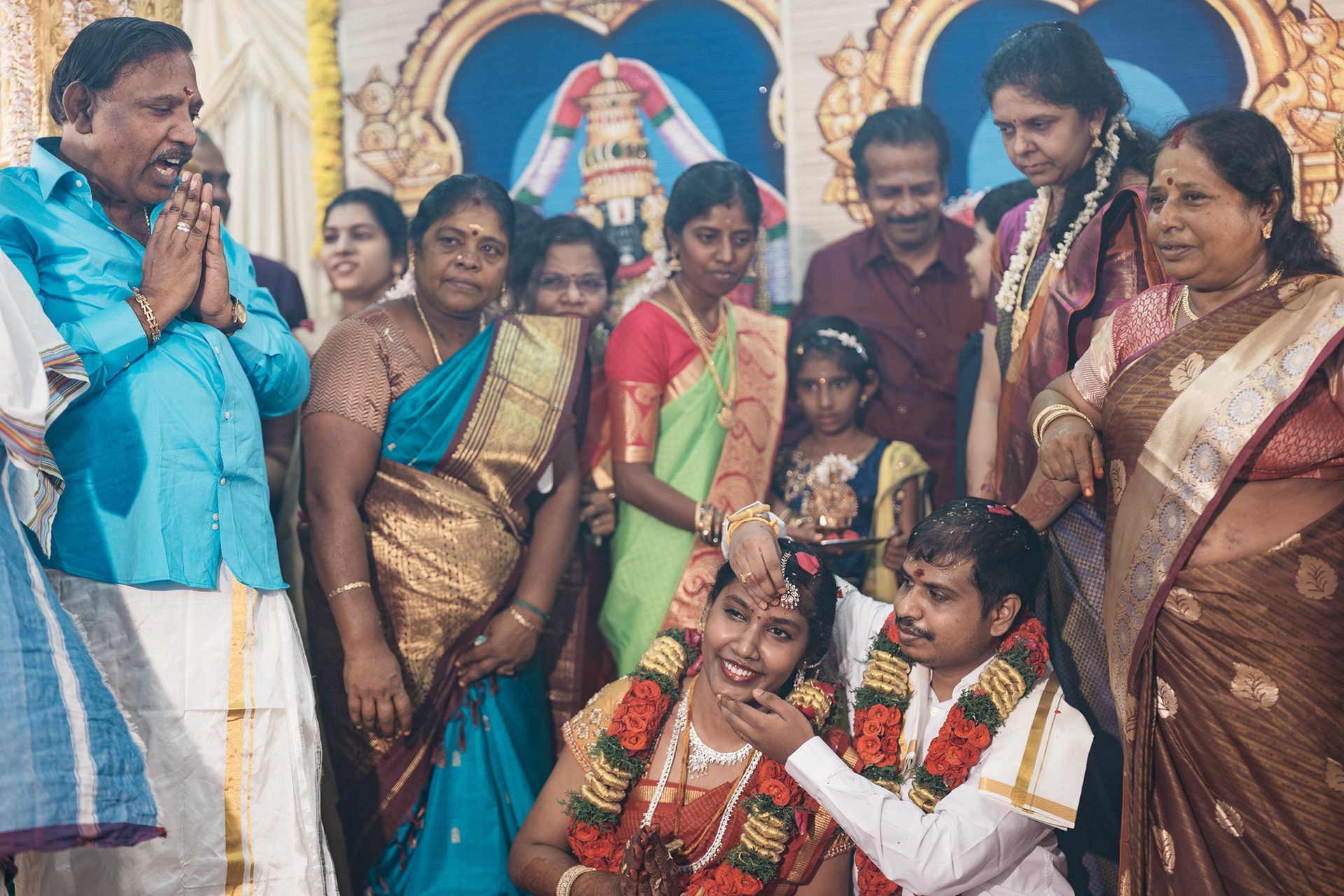 Groom puts pottu on bride's fore head