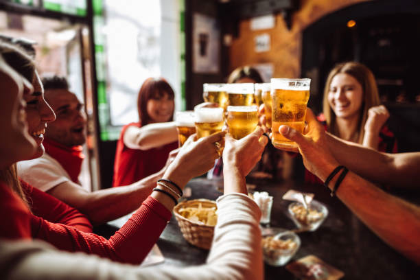 Group of people at a restaurant holding out their glasses to cheers one another 