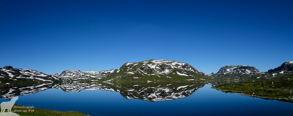 Perfecte weerspiegeling van besneeuwde bergen, Haukelifjell, Noorwegen, 2016.