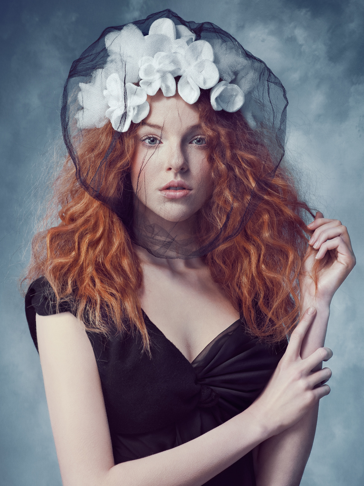 Fine art portrait of red-haired model wearing large black hat with white floral accents – Joanna Kustra couture fashion photography