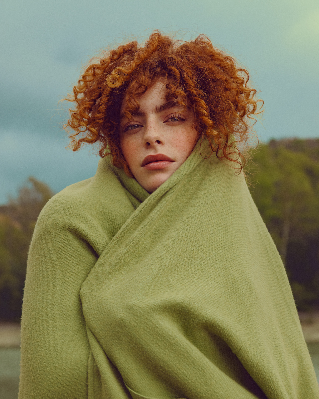 Luxury fashion portrait of model with curly red hair wrapped in green coat – Joanna Kustra, Marbella fashion photography