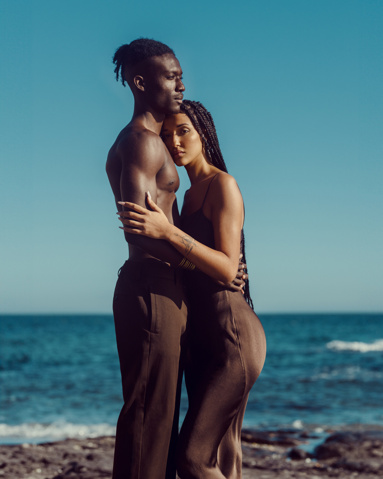 Romantic editorial portrait of fashion couple embracing on beach – Joanna Kustra, destination fashion photography