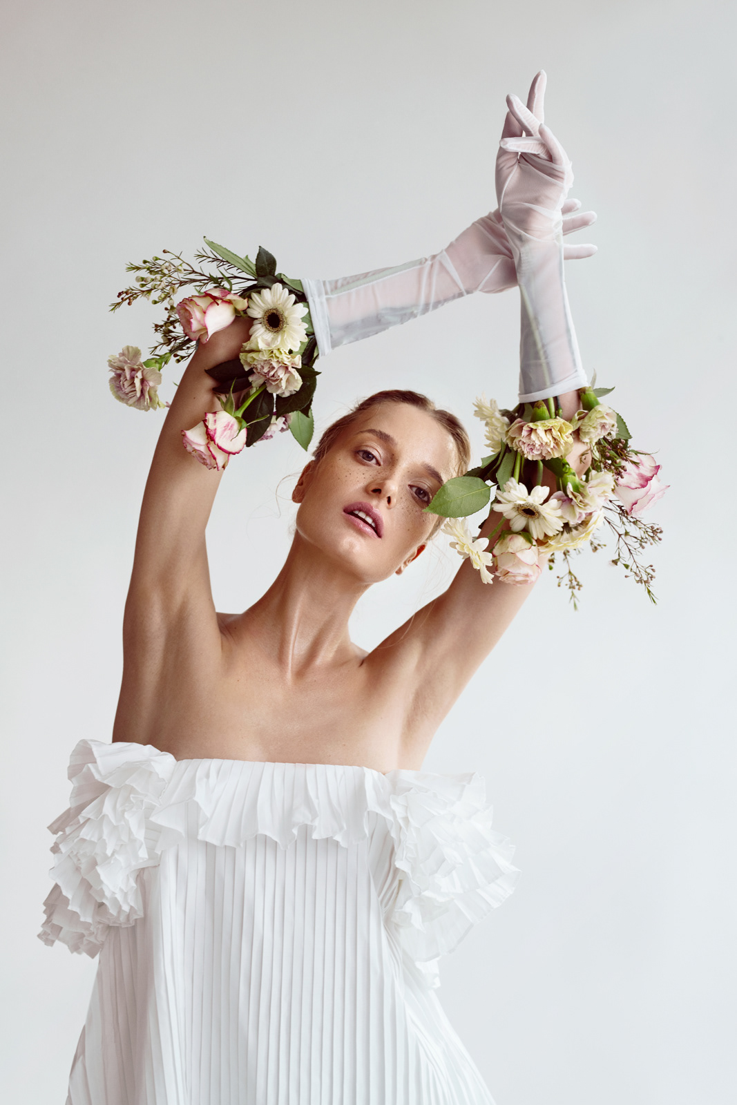 Minimalist white studio fashion portrait with gloves and floral accessories – Joanna Kustra conceptual photography