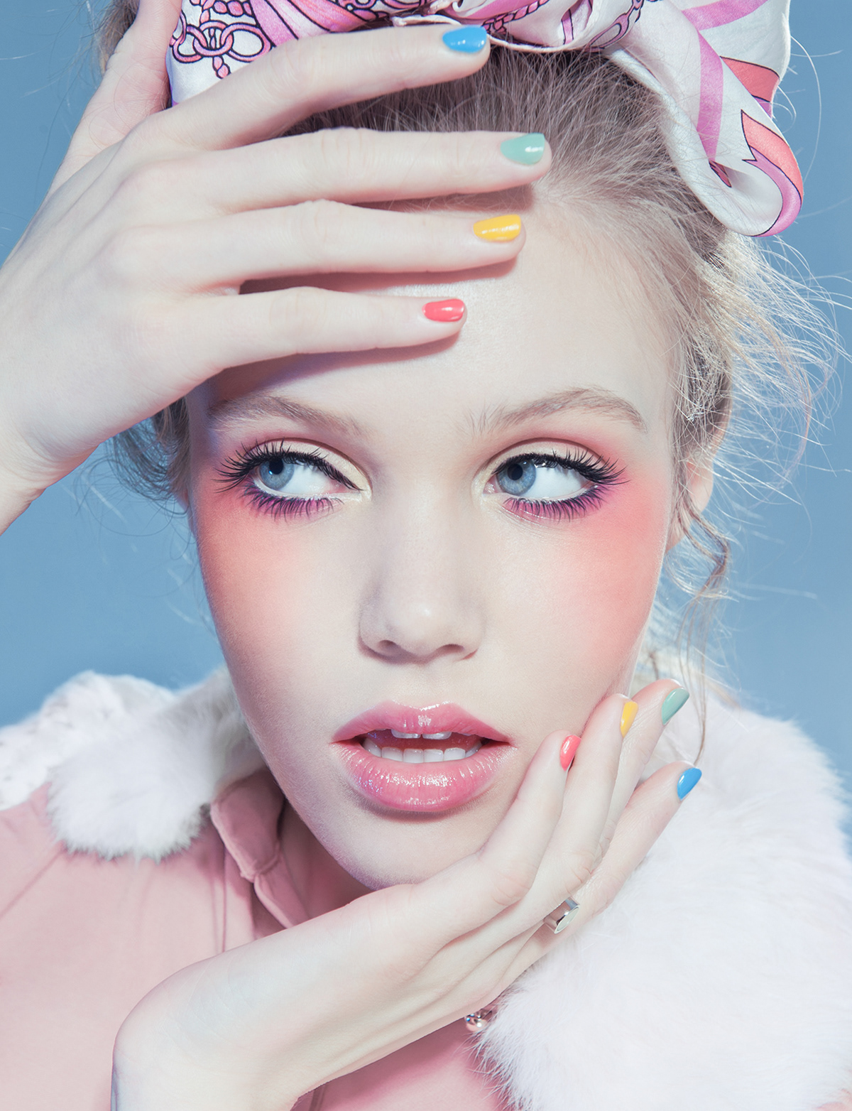 Editorial beauty portrait of blonde model with pastel nail polish and pink makeup against blue backdrop – Joanna Kustra creative beauty photography