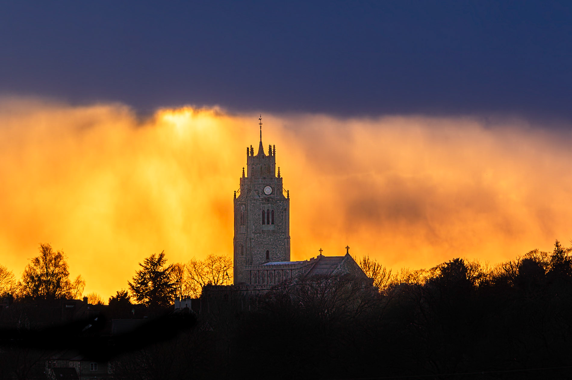 Sunset behind St Andrew's Chruch tower, (The Pepperpot), Sutton-in-the-Isle, Cambridgeshire. 6th April 2021