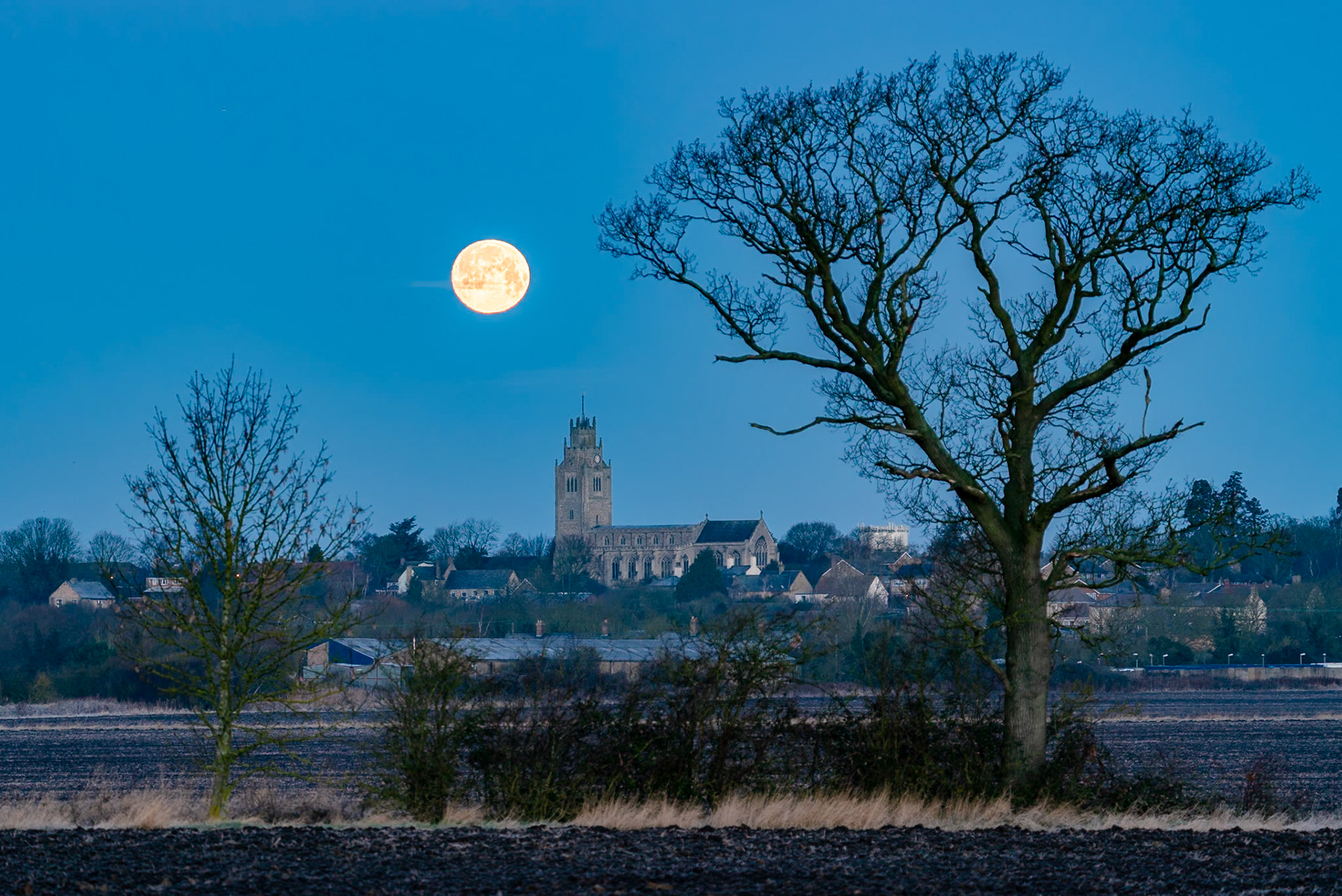 Wolf Moon setting over St Andrew's Chrurch, Sutton-in-the-Isle, Cambridgeshire, 17th January 2022