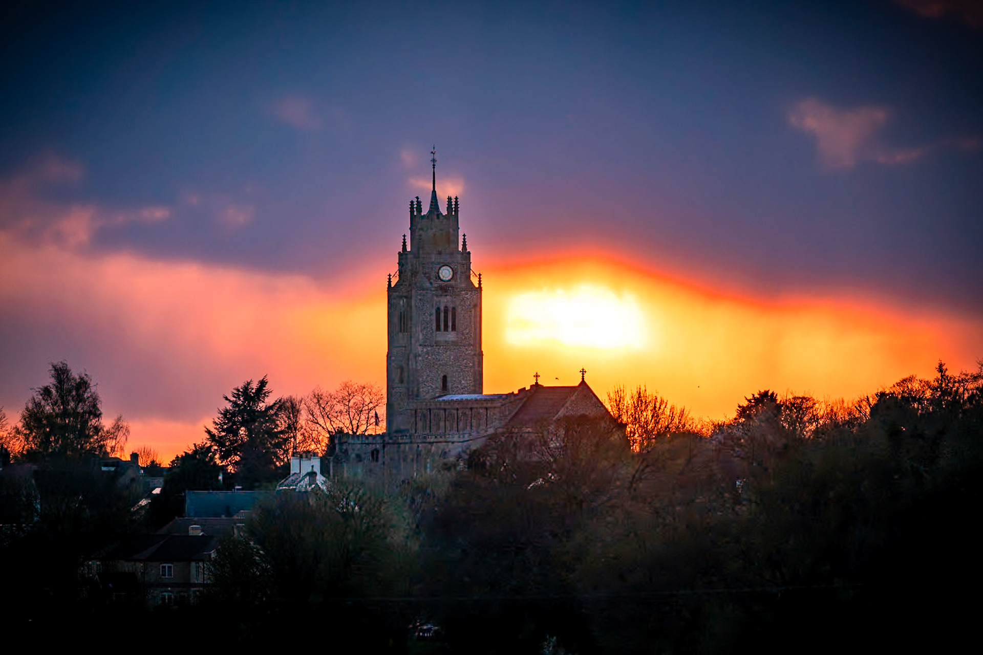 Sunset behind St Andrew's Chruch tower, (The Pepperpot), Sutton-in-the-Isle, Cambridgeshire. 6th April 2021