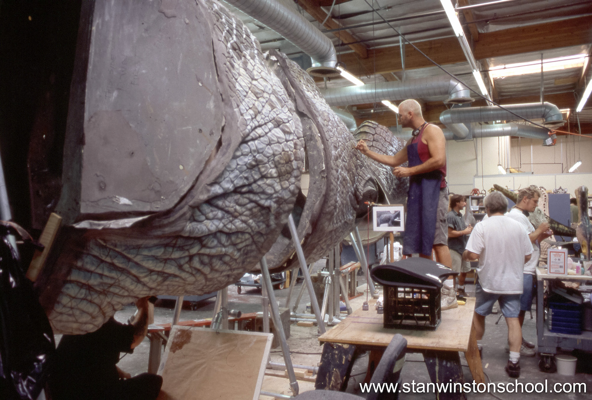 Painting details onto the skins of the gigantic Spinosaurus puppet.