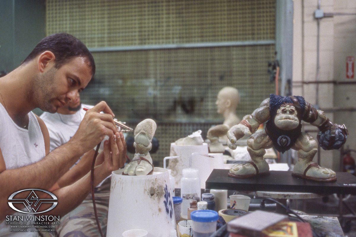 Painting one of the leg parts while referencing the master painted sculpture to make sure they match.