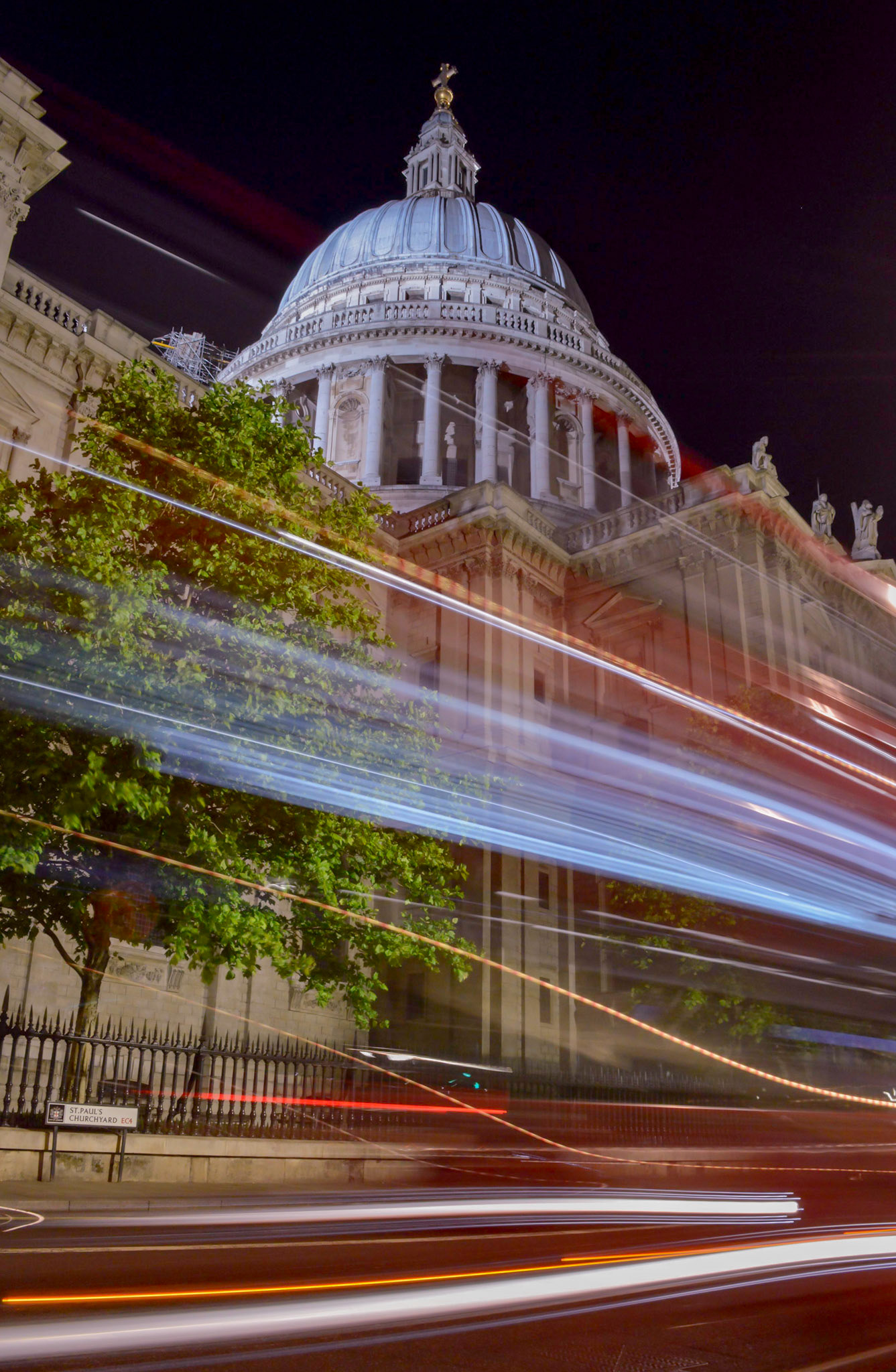 London bus buzzing past St Paul's Cathedral at night