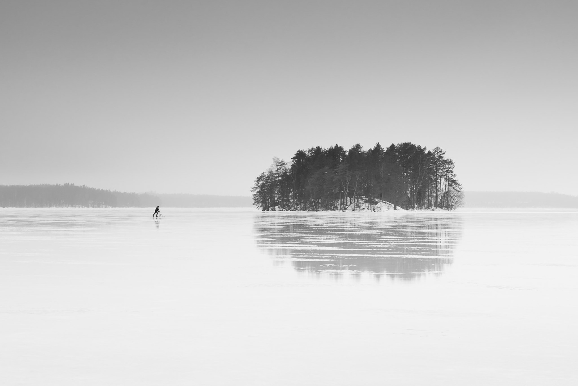 Ice rider glides across frozen lake and landscape, Finland. Costas Kariolis