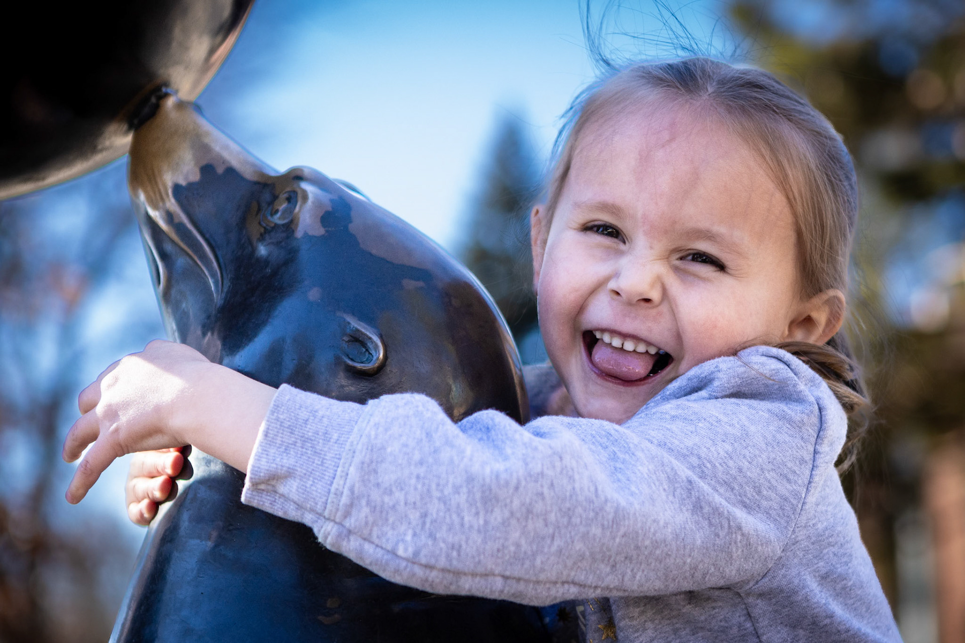 Playing with a seal sculpture at the Denver Zoo