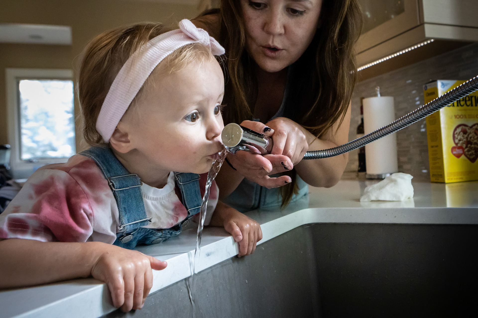 Sneaking a drink from the kitchen faucet.