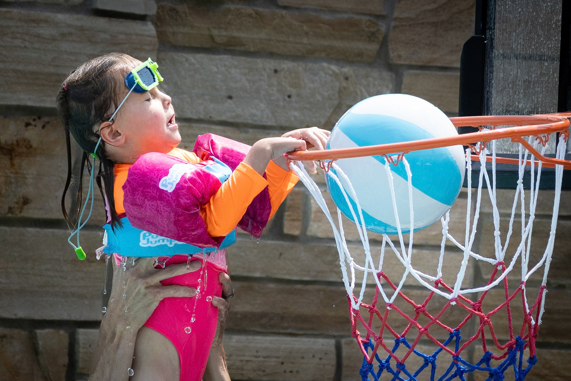 Practicing her dunk with an assist from Dad
