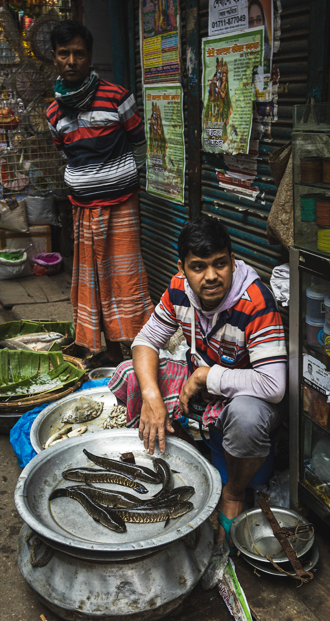 A young man selling fish on Hindu Street in Old Dhaka, Bangladesh.