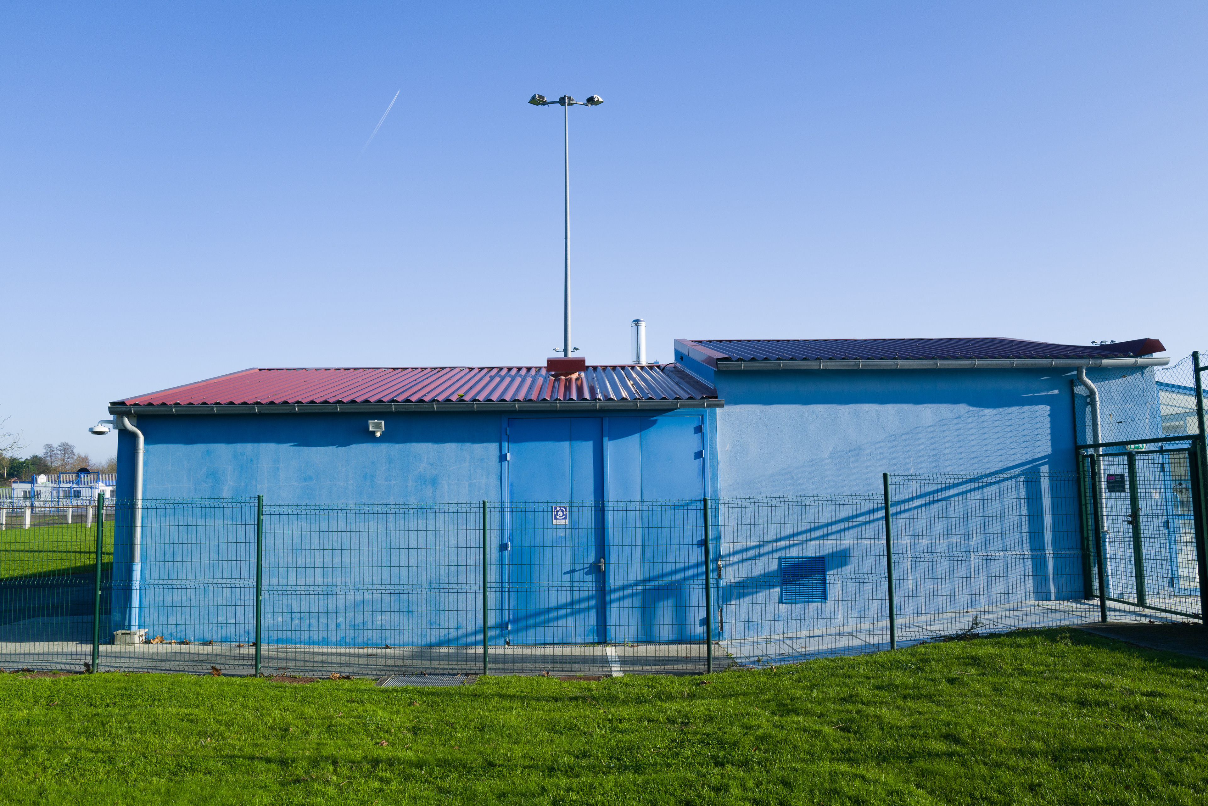 la machinerie de la piscine municipale, un batiment bleu sur fond de ciel bleu.