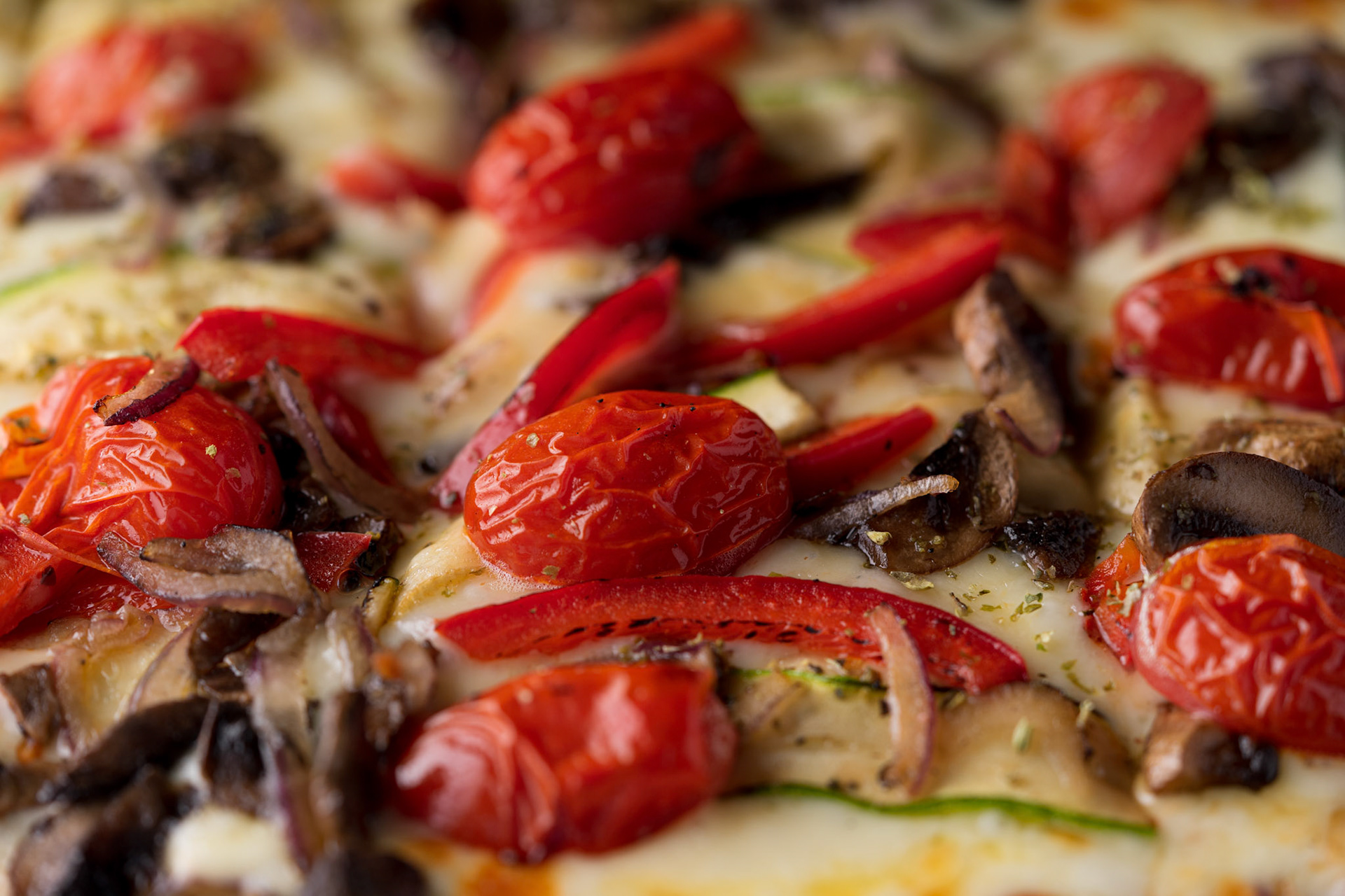 Detalle de pizza y tomates cherry asados con queso mozzarella en Mia Bar