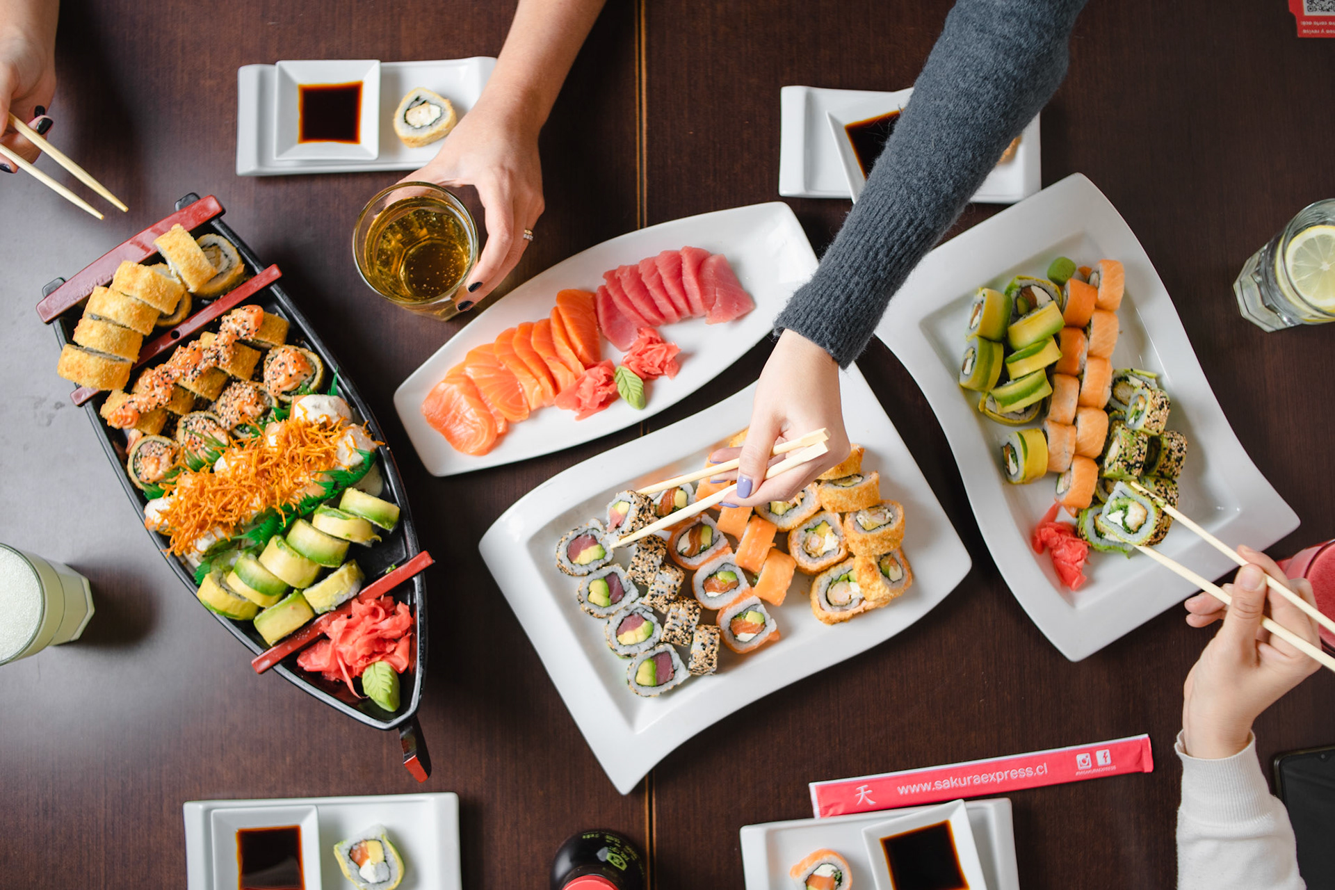 Personas compartiendo sushi en Sakura Sushi, fotografo de alimentos