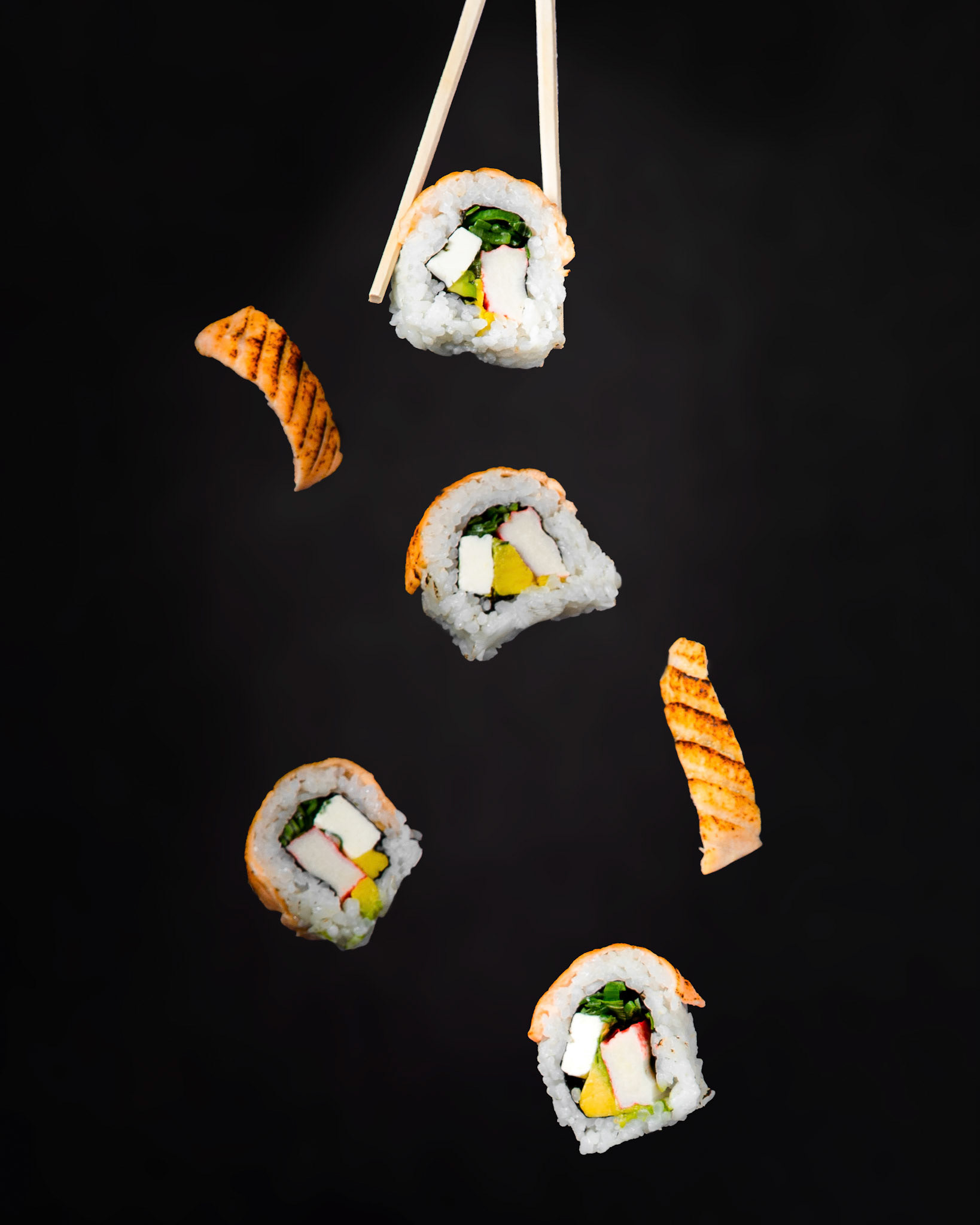Diferentes rolls de sushi cayendo en una composición fotográfica