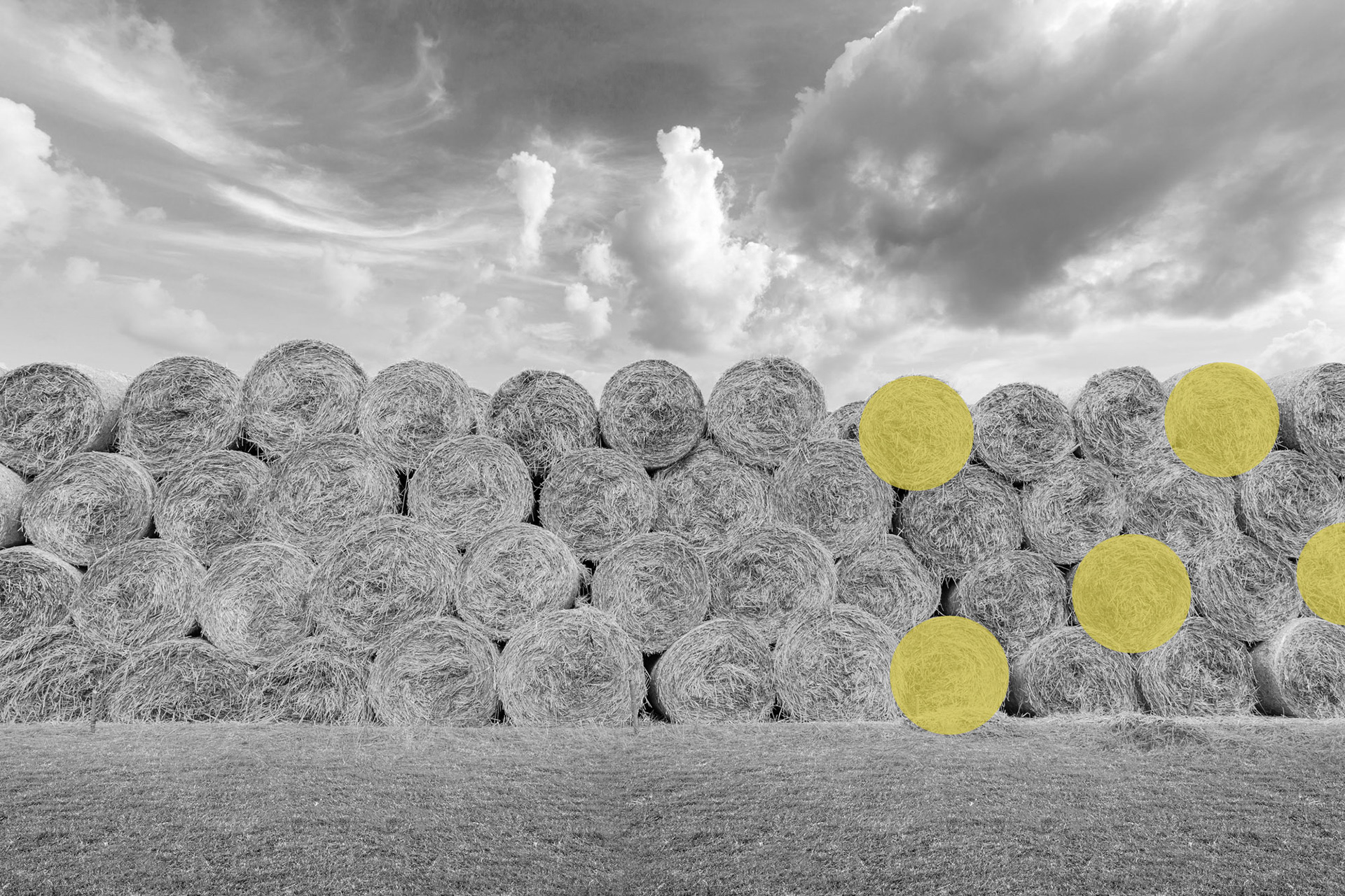 Straw bales on farmland with blue cloudy sky