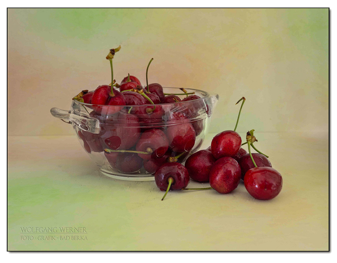 Kirschen im Glas auf farbigem Grund