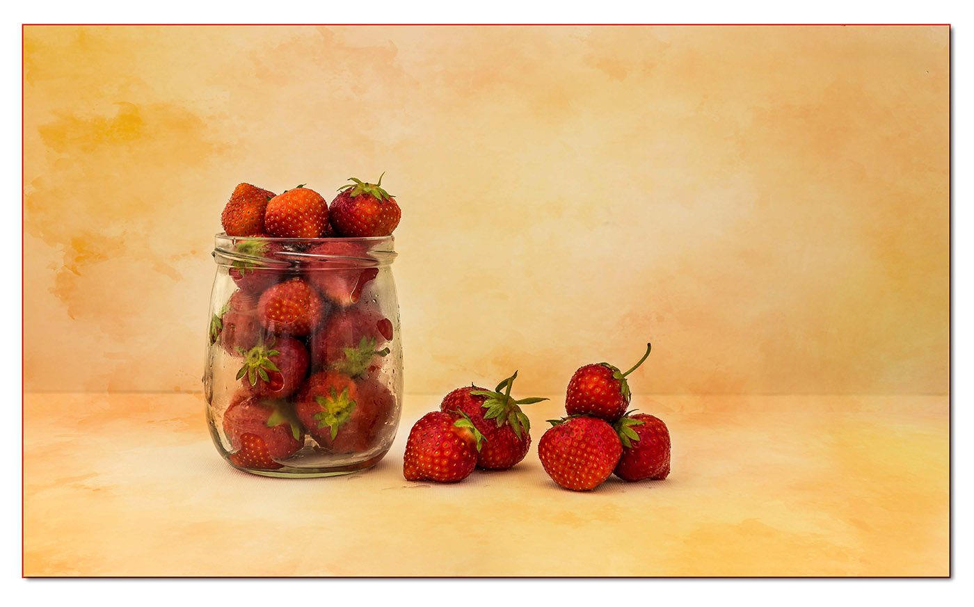 Erdbeeren im Glas auf farbigem Grund