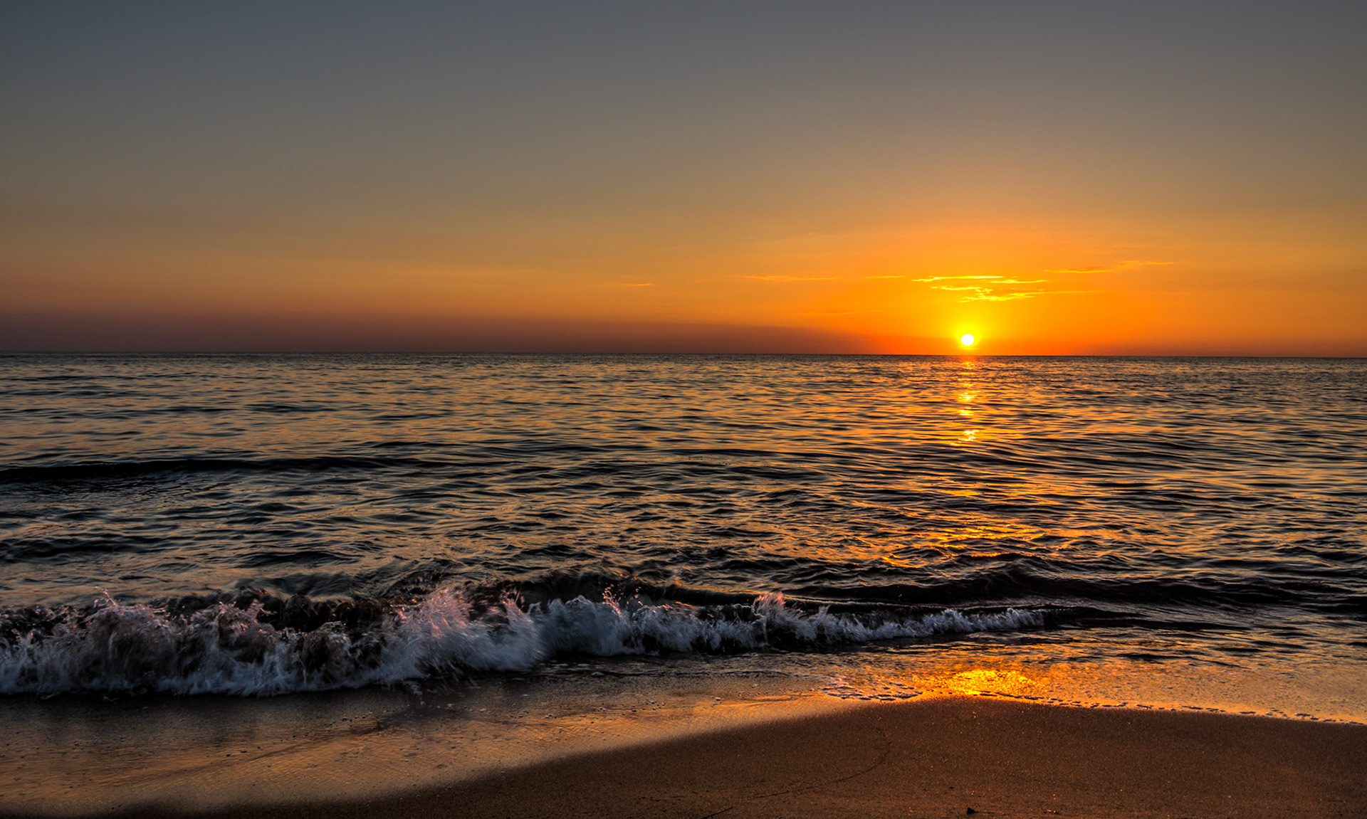 Prächtiger Sonnenuntergang in einer einsamen Bucht am Horizont.