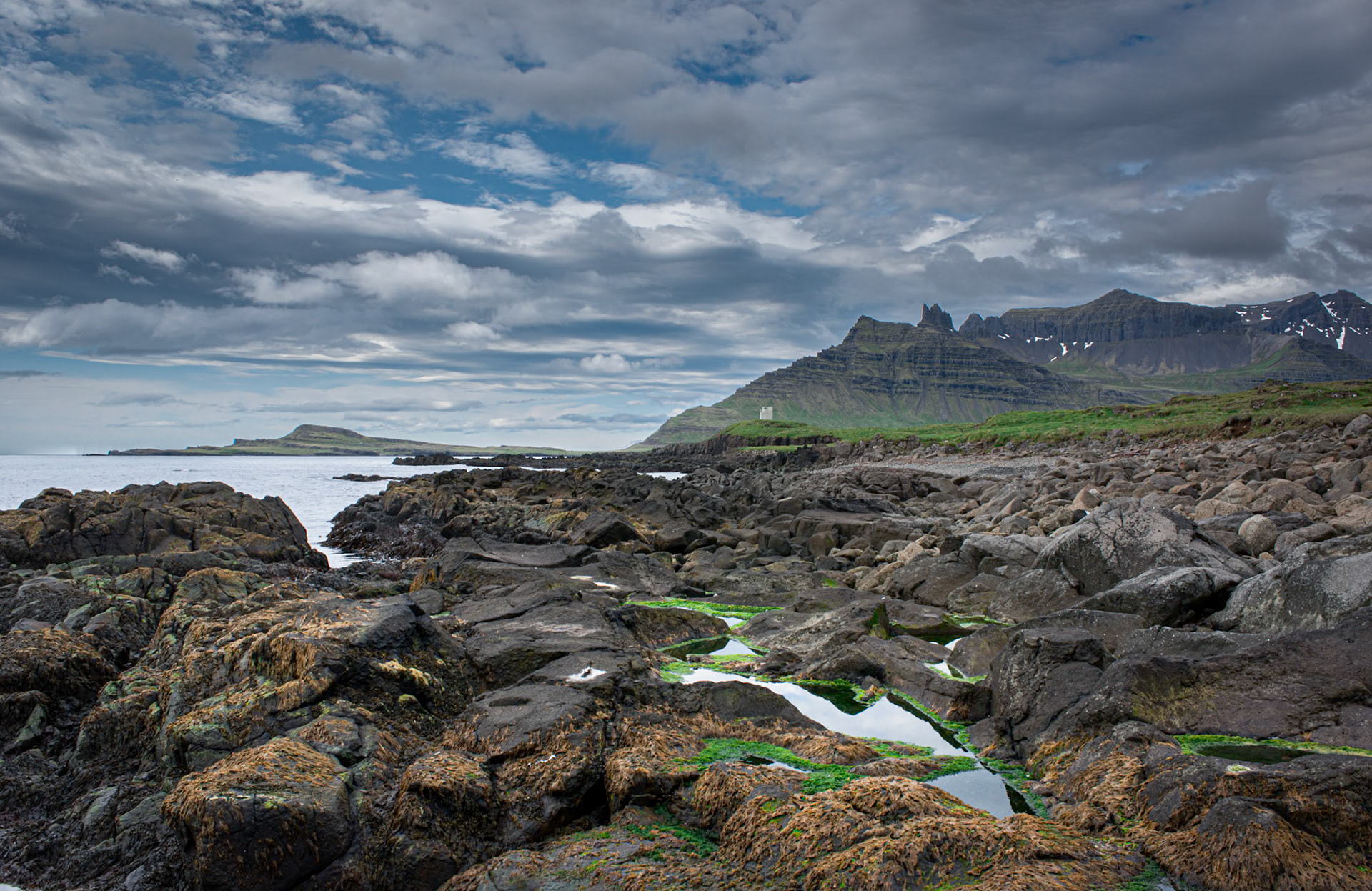 Stöðvarfjörðu -A rocky shore with a view to Kambanes and Súlur.Location: Stöðvarfjörður, East Iceland.