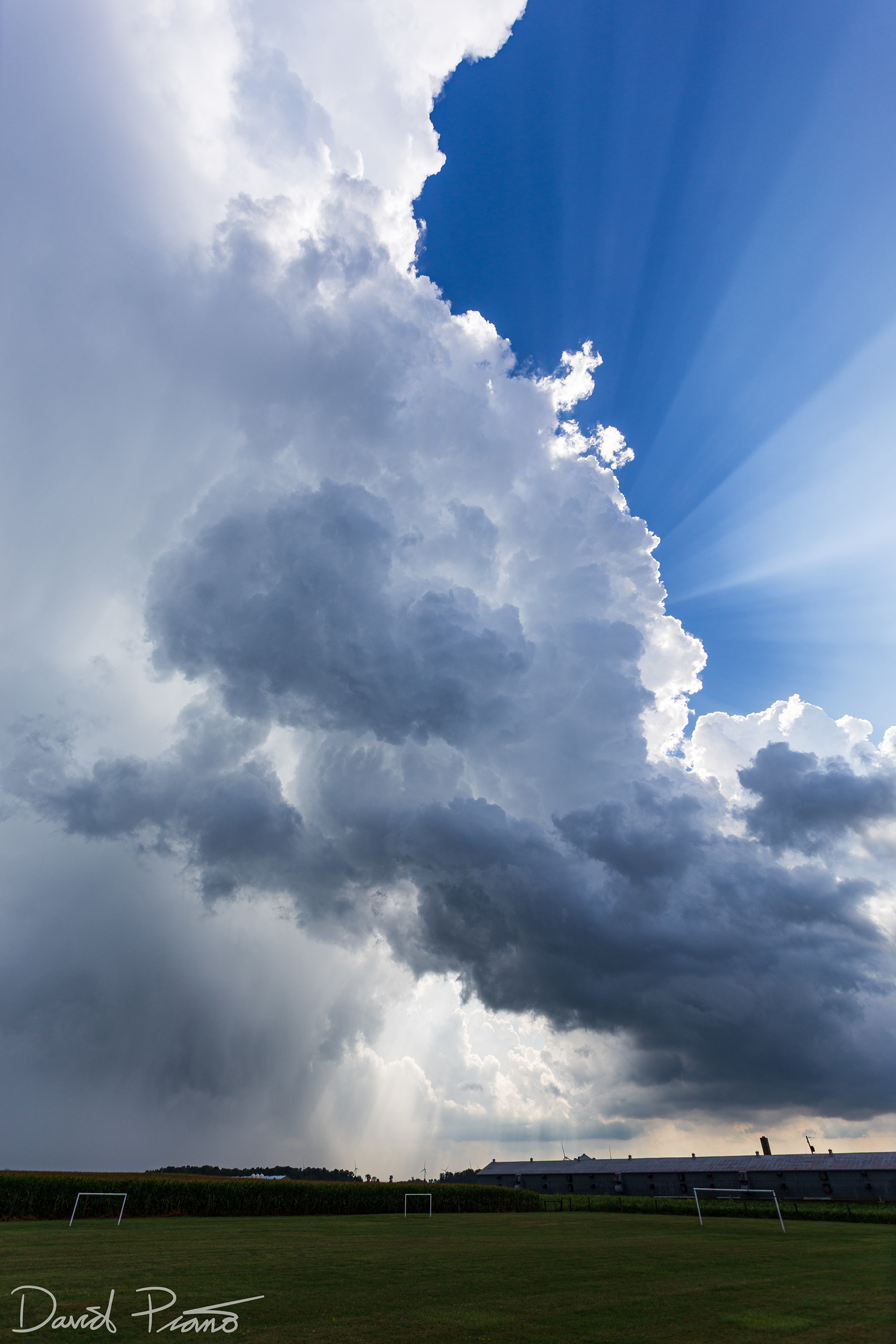 Crepuscular rays fan out from behind a towering CB near Strathroy