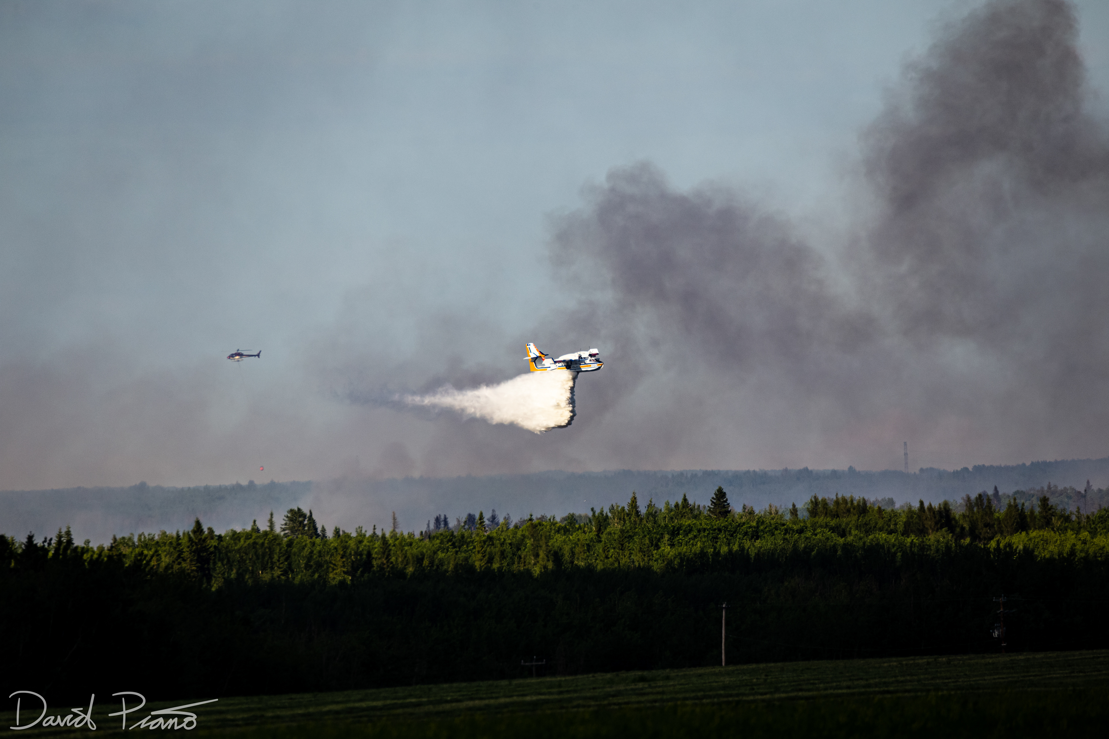 An Alberta CL-415 water bomber works to suppress a raging wildfire near the Yellowhead Highway in Alberta - June 2021