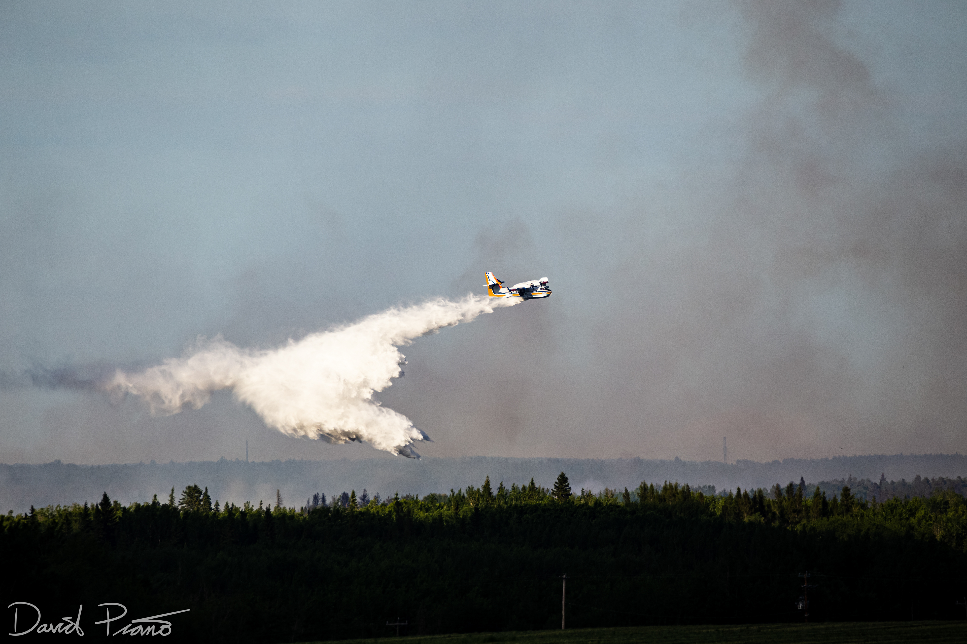 An Alberta CL-415 water bomber works to suppress a raging wildfire near the Yellowhead Highway in Alberta - June 2021