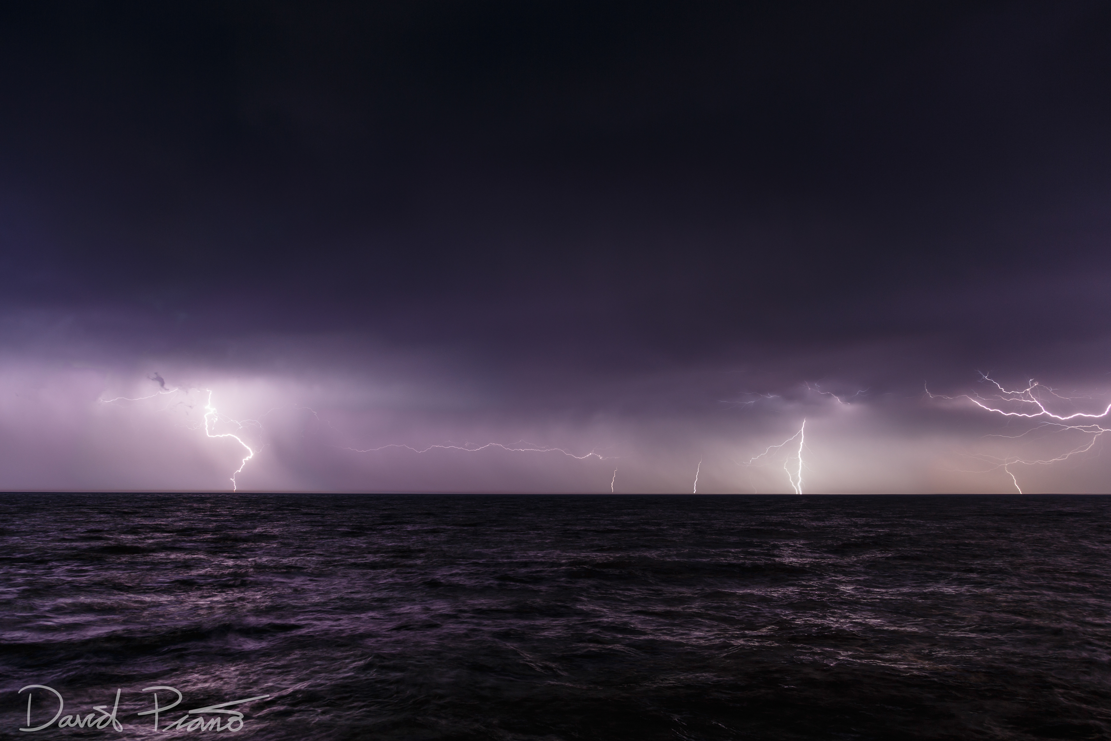 Lightning strikes occur over Lake Erie during an early season thunderstorm - -