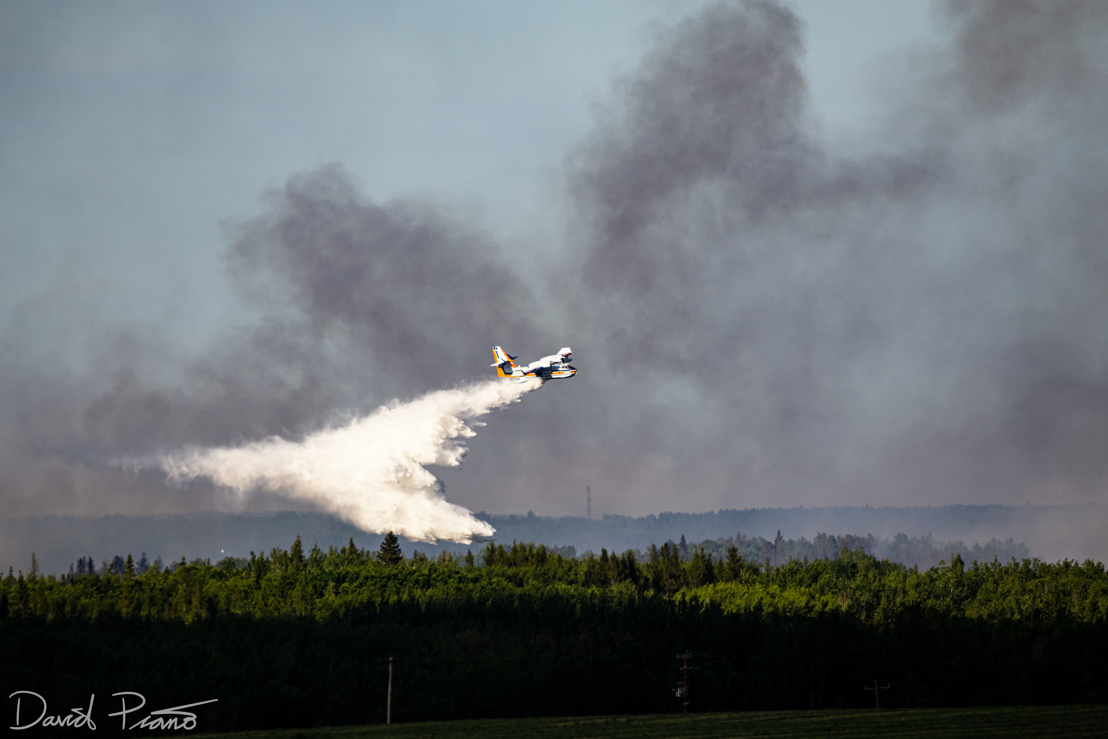 An Alberta CL-415 water bomber works to suppress a raging wildfire near the Yellowhead Highway in Alberta - June 2021