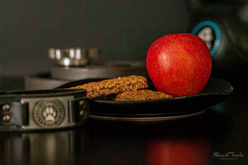 Granola bars with apple and assorted fitness weights.