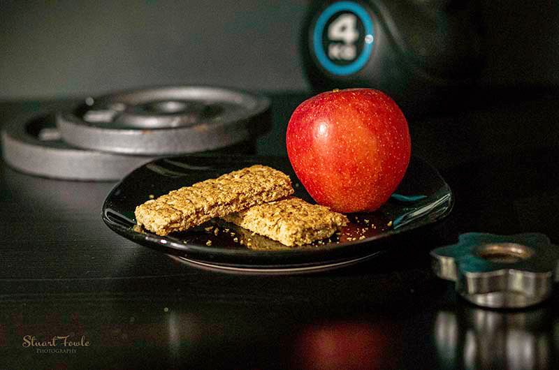 Granola bars with apple and assorted fitness weights.