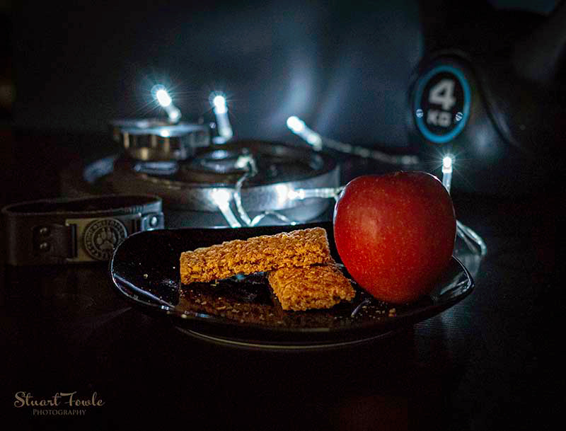 Granola bars with apple and assorted fitness weights.