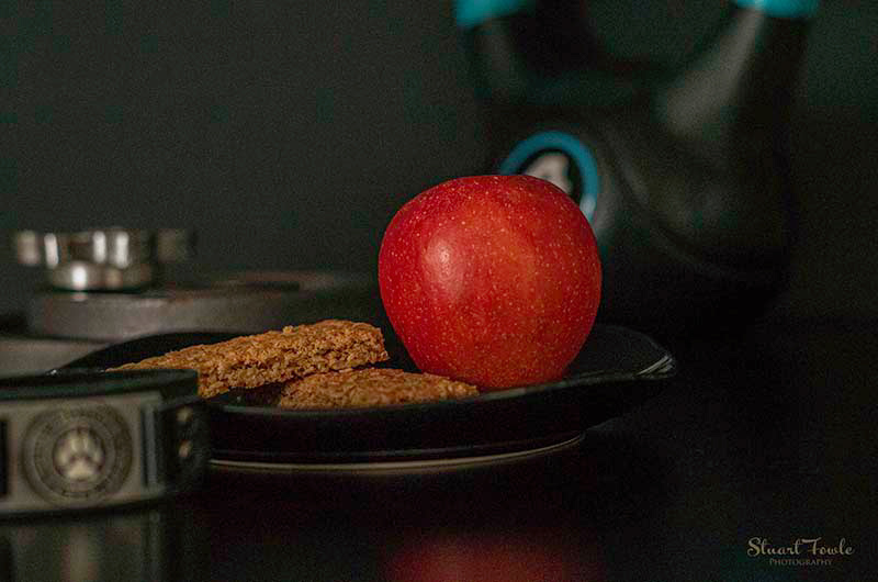 Granola bars with apple and assorted fitness weights.