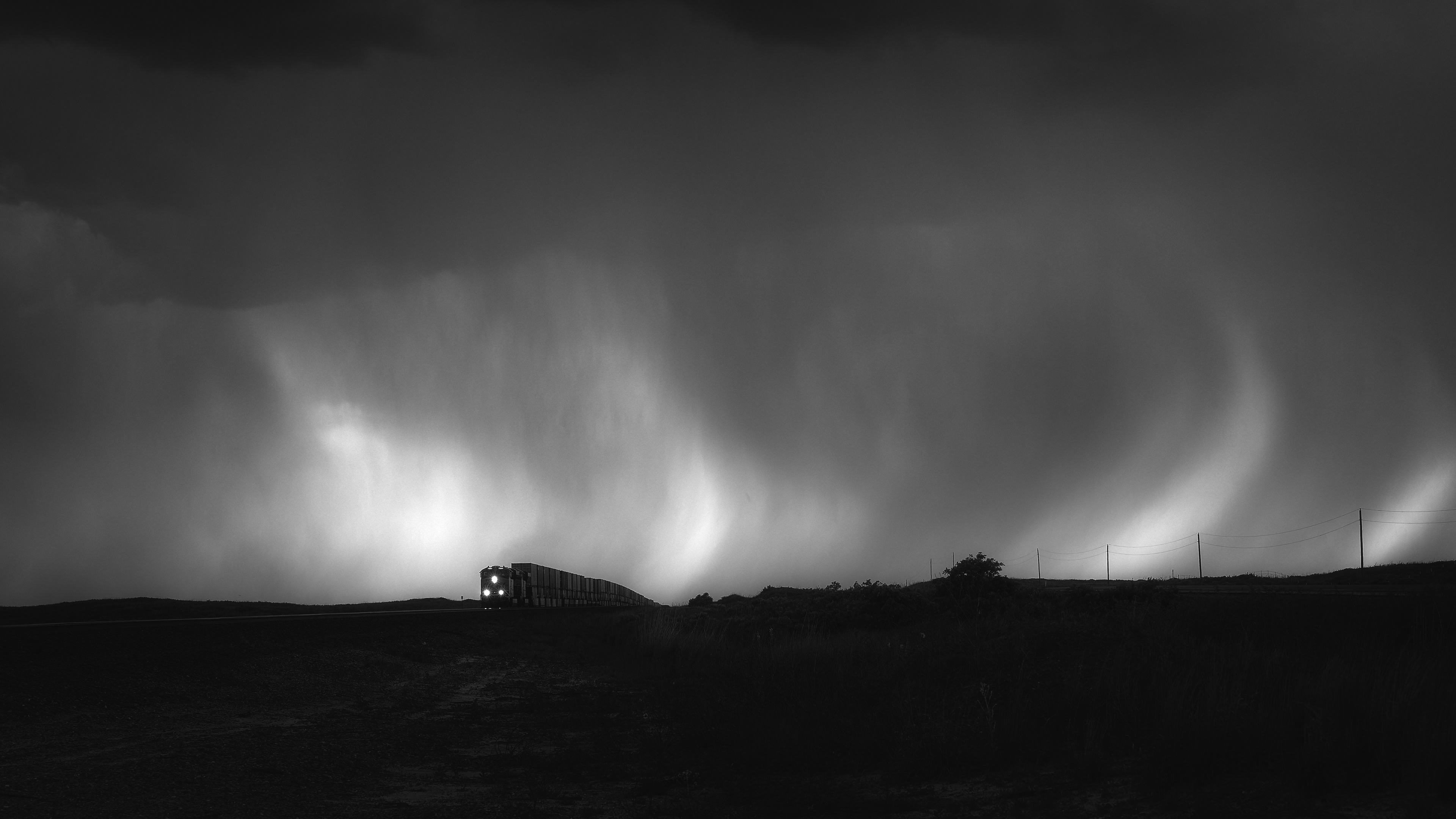The Gods of Rain pummel the land and all those who venture across it. This eastbound BNSF train tops the grade out of the Canadian River Valley a Coburn, Texas, as a vicious thunderstorm pounds the Panhandle of Texas.